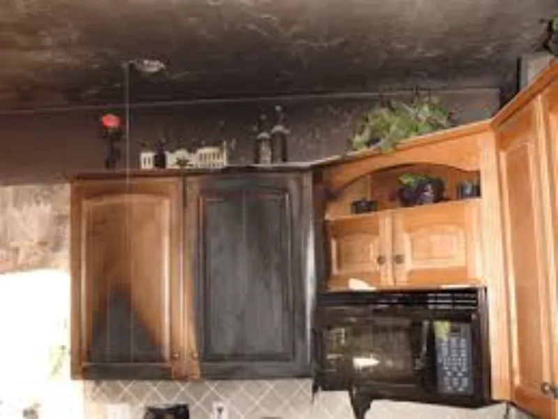 Kitchen cabinets and ceiling severely damaged by fire and smoke.