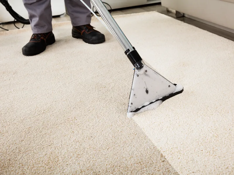 Carpet cleaning machine removing dirt from a beige carpet.